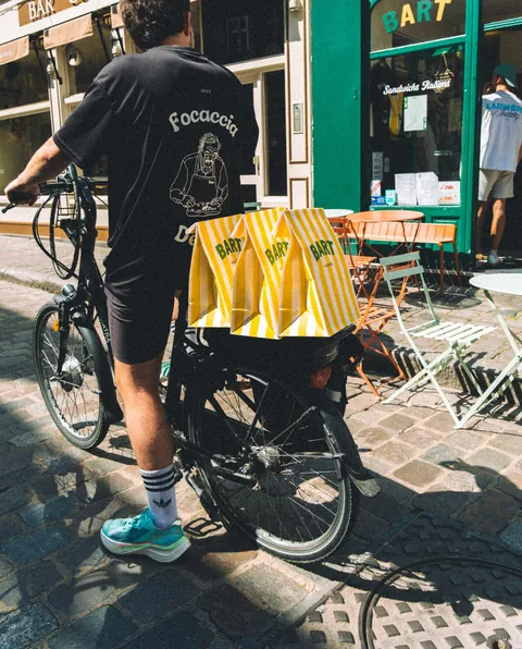 Vélo chargé de sacs Bart rayés devant la boutique de Lille